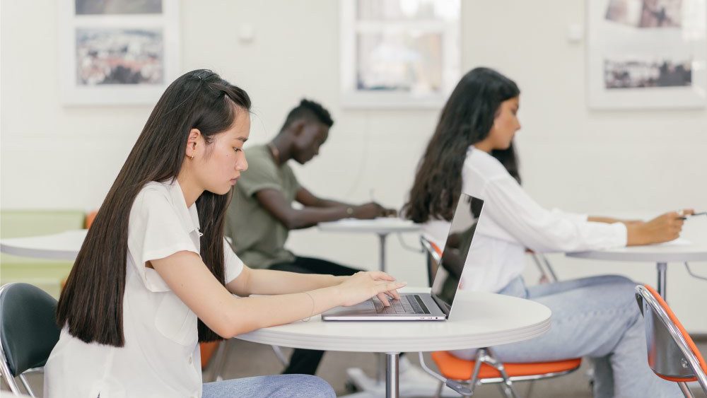 novas tecnologias na educação ajudando aluna em sala de aula
